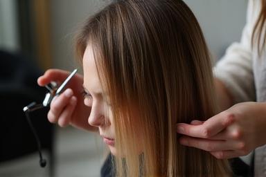 Coiffeuse professionnelle réalisant une coupe moderne sur cheveux longs